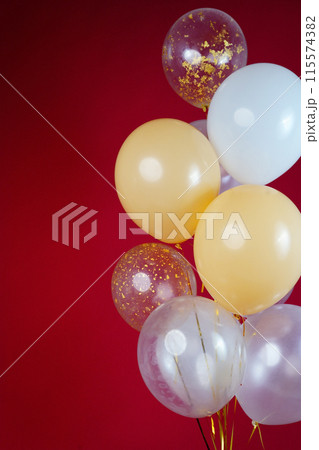 A bunch of light balloons on a red background. Vertical Photo Space for Text 115574382