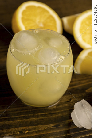 ripe sliced lemon and cold juice with ice and their reflection on a wet table ripe sliced lemon and cold juice with ice and their reflection on a wet table 115574661