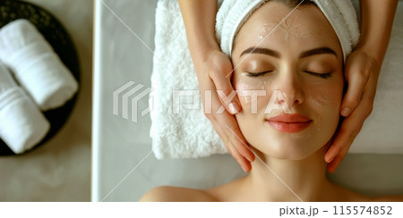 Woman with towel on head getting facial massage at spa 115574852