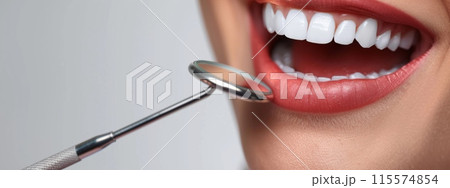 A woman is at the dentist having her teeth checked 115574854