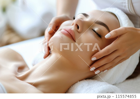 A woman is indulging in a relaxing facial massage at a spa 115574855