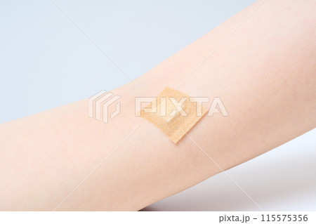 注射を打った後にパッチを貼られた腕 注射を打った後にパッチを貼られた腕 115575356