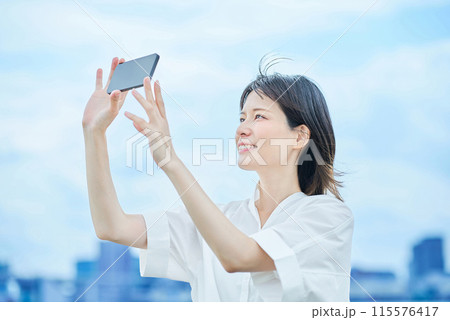 スマートフォンの画面を見る若い女性 115576417