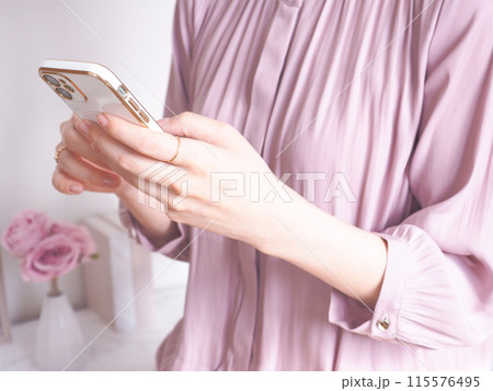 スマートフォンを操作する女性と女性らしいインテリア スマートフォンを操作する女性と女性らしいインテリア 115576495