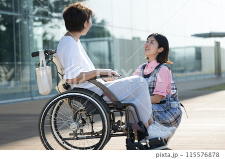 車椅子に乗る中年女性と介護士のイメージ 115576878