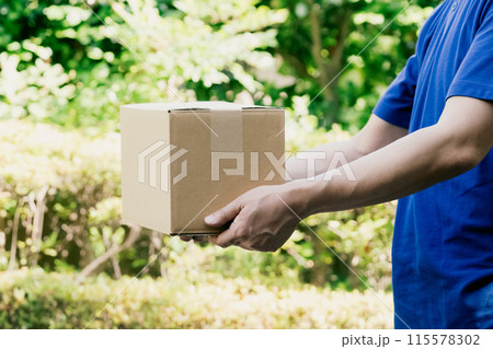 荷物を持つ配達員の男性 荷物を持つ配達員の男性 115578302