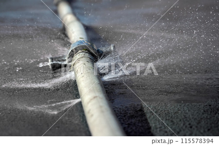 Water leaking from hole in a hose. 115578394