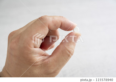 薬を指でつまむ 薬を指でつまむ 115578940