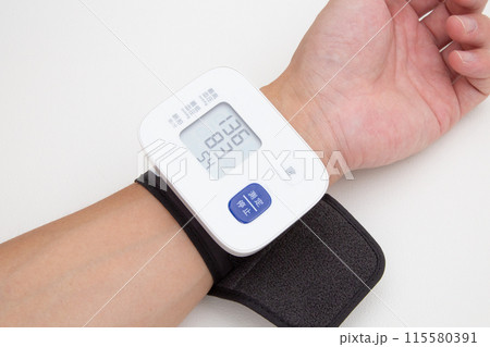 手首式血圧計で血圧測定する 115580391