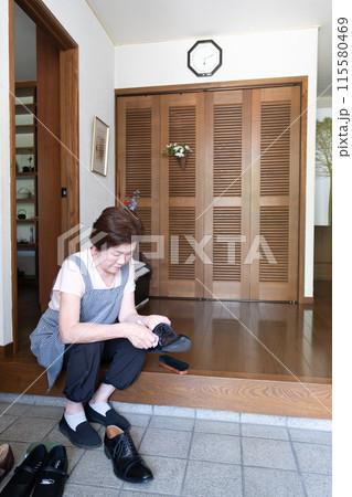 靴磨きをするシニア女性 115580469