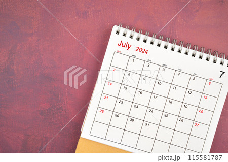 July 2024 desk calendar on red background. 115581787