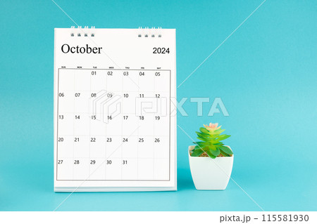 2024 October desk calendar and plant pot on blue background. 2024 October desk calendar and plant pot on blue background. 115581930