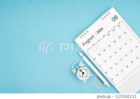 August 2024, Monthly desk calendar for 2024 year and alarm clock with paper clips on blue color background. 115582213
