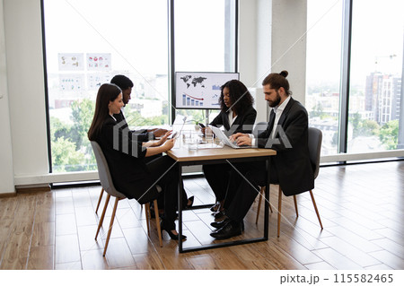 Diverse group of business professionals in a modern office meeting 115582465