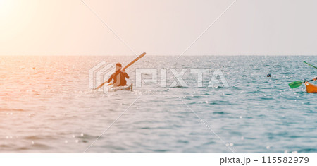 Woman sea kayak. Happy smiling woman in kayak on ocean, paddling with wooden oar. Calm sea water and horizon in background. Active lifestyle at sea. Summer vacation. 115582979