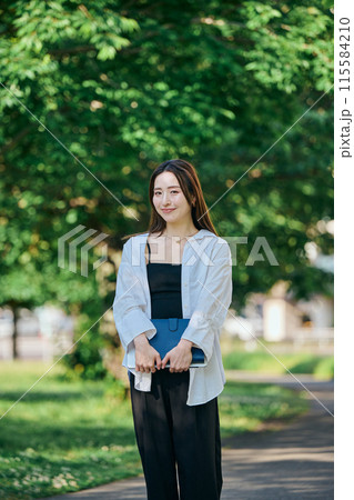 手帳を持って歩く若い女性 手帳を持って歩く若い女性 115584210
