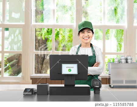 Active asian seller wear green uniform smiling with point of sale terminal or cashier desk 115585788