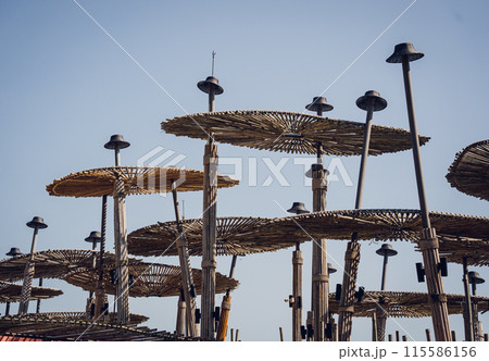 A wooden umbrellas set against the backdrop of a clear blue sky A wooden umbrellas set against the backdrop of a clear blue sky 115586156