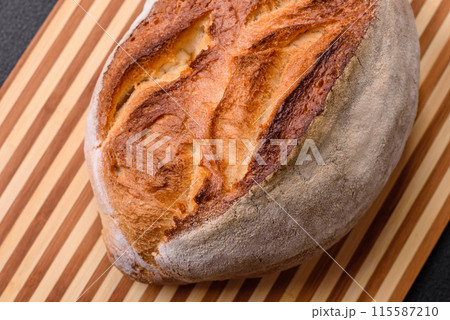 A loaf of brown bread with grains of cereals 115587210