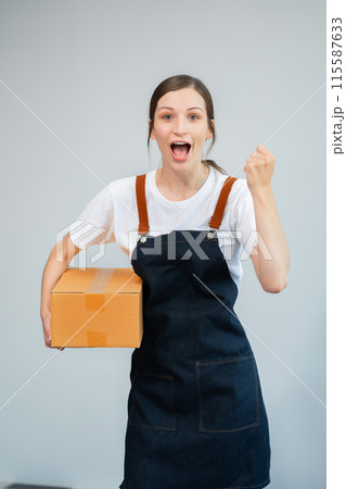woman holding parcels box and looking to camera, isolated on white background. 115587633