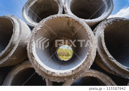 A stack of concrete ring pipes piled and creating a symmetrical arrangement 115587942