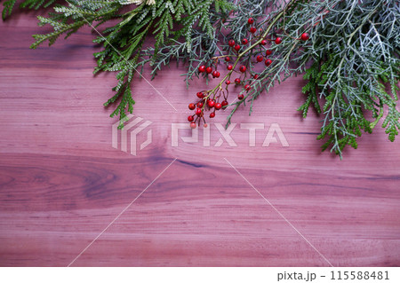 木目背景に置かれたクリスマスリース、クリスマスグリーンデコレーション背景 木目背景に置かれたクリスマスリース、クリスマスグリーンデコレーション背景 115588481