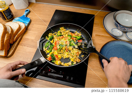 Chef at the kitchen preparing tofu scramble with vegetables 115588619