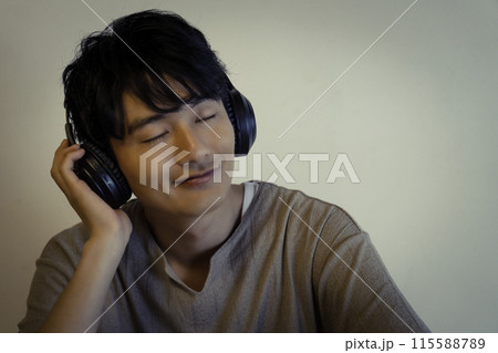 ヘッドホンで音楽を聴く若い男性 ヘッドホンで音楽を聴く若い男性 115588789