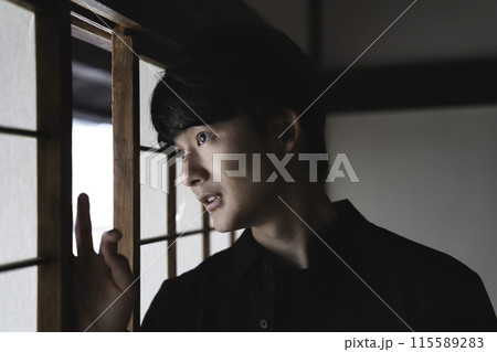 張り込みをする男性 115589283