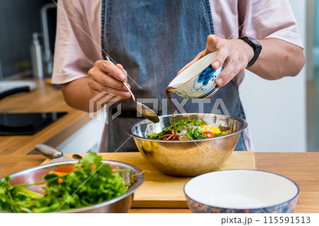 Chef at the kitchen preparing spicy glass noodle salad 115591513