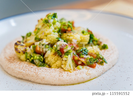 Tasty bean porridge with cauliflower and vegetables on white plate Tasty bean porridge with cauliflower and vegetables on white plate 115591552