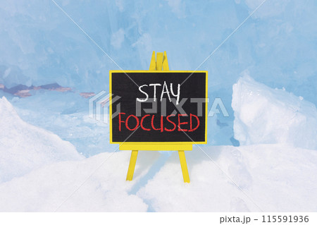 Stay focused symbol. Concept words Stay focused on beautiful yellow black blackboard. Beautiful blue ice background. Business, support, motivation, psychological stay focused concept. Copy space 115591936