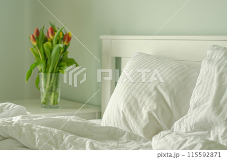 bedroom with tulips and white pillow  115592871