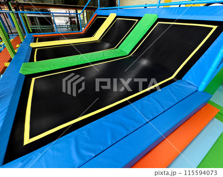 A room filled with an array of vibrant trampolines A room filled with an array of vibrant trampolines 115594073