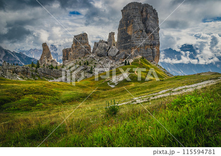 Green meadow and Cinque Torri rock formations, Dolomites 115594781