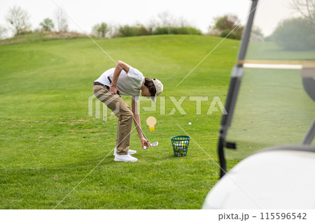 Young guy exercising in playing golf and looking concentrated 115596542