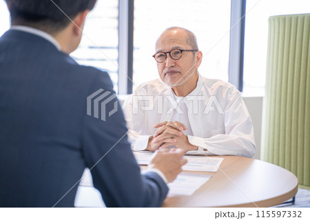 商品サービスの説明を受ける男性シニア 商品サービスの説明を受ける男性シニア 115597332
