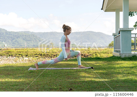 yogi girl in vibrant yoga sportswear performs stretch in open gazebo yogi girl in vibrant yoga sportswear performs stretch in open gazebo 115600446