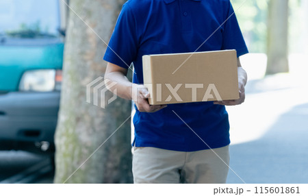 荷物を持つ配達員の男性 115601861