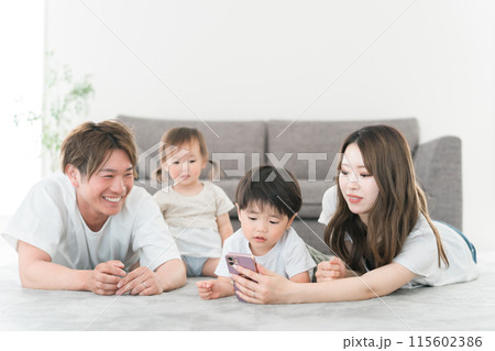 家のリビングでスマホを見る笑顔の日本人家族（動画・ファミリー） 115602386