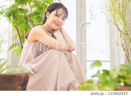 観葉植物の緑に囲まれて微笑む女性 115602835