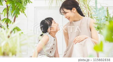 植物に囲まれて見つめ合う母と娘 115602838