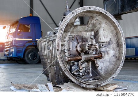A disassembled industrial truck transmission awaiting repair or recycling, placed on a wooden pallet A disassembled industrial truck transmission awaiting repair or recycling, placed on a wooden pallet 115604770