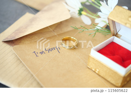 Note with the sorry word next to a wedding ring. Note with the sorry word next to a wedding ring. 115605622