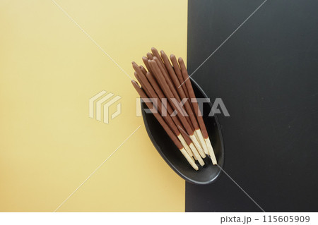 Chocolate Biscuit Sticks on a Stylish Black and Yellow Background, Ideal for Food Photography 115605909