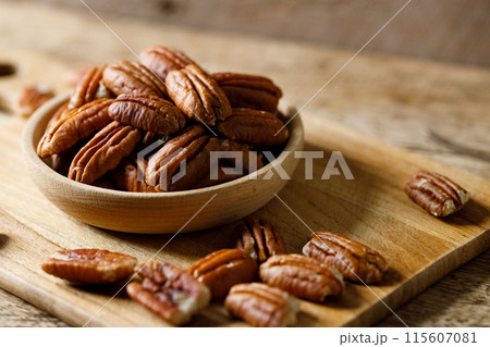 Pecan nuts in a wooden bowl Pecan nuts in a wooden bowl 115607081