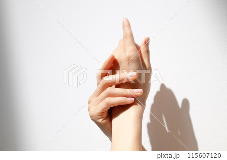 日差しを浴びる女性の手元 115607120