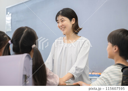 学校の教壇で生徒と話す教師のイメージ 学校の教壇で生徒と話す教師のイメージ 115607595