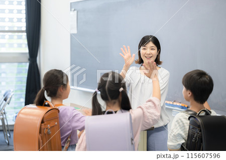 小学校の教室でさようならをする先生と生徒 小学校の教室でさようならをする先生と生徒 115607596