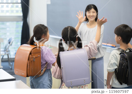 小学校の教室でさようならをする先生と生徒 小学校の教室でさようならをする先生と生徒 115607597